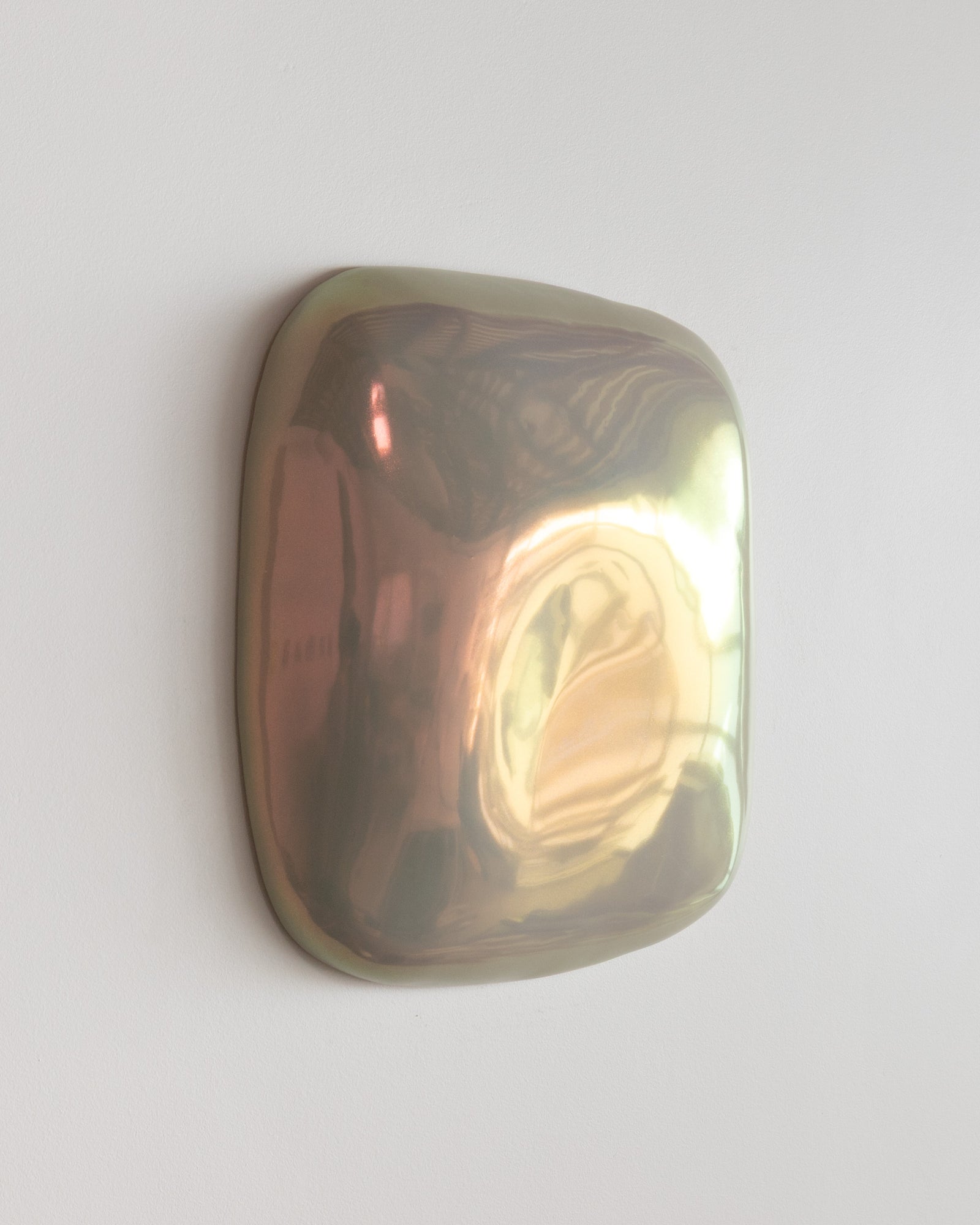 Angled view of an iridescent ceramic fragment with warm reflections