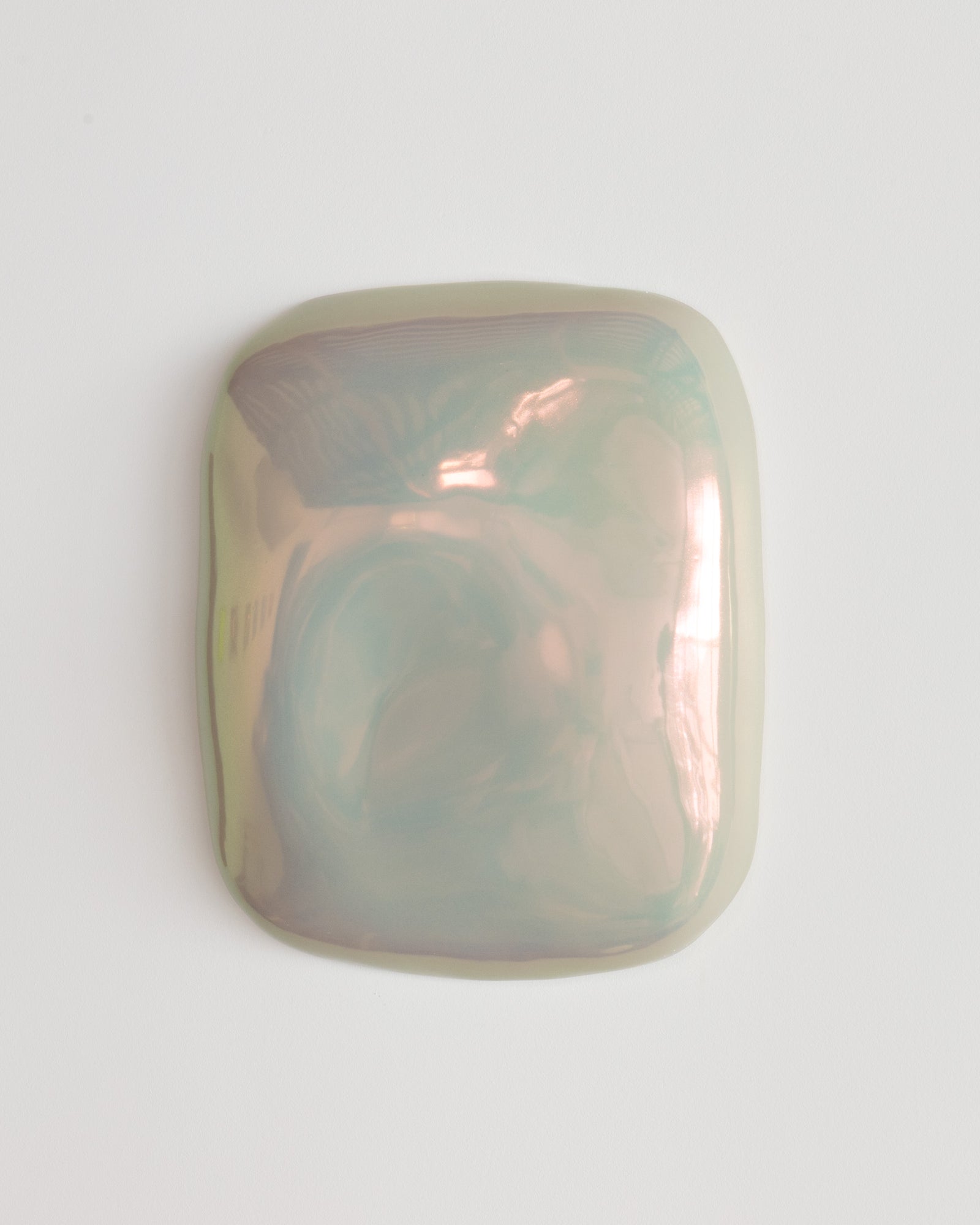 Small iridescent ceramic fragment on a white background