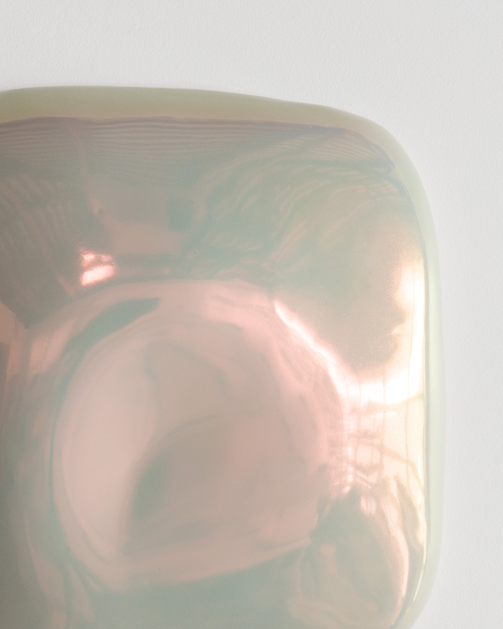 Close-up of an iridescent ceramic fragment with pink reflections