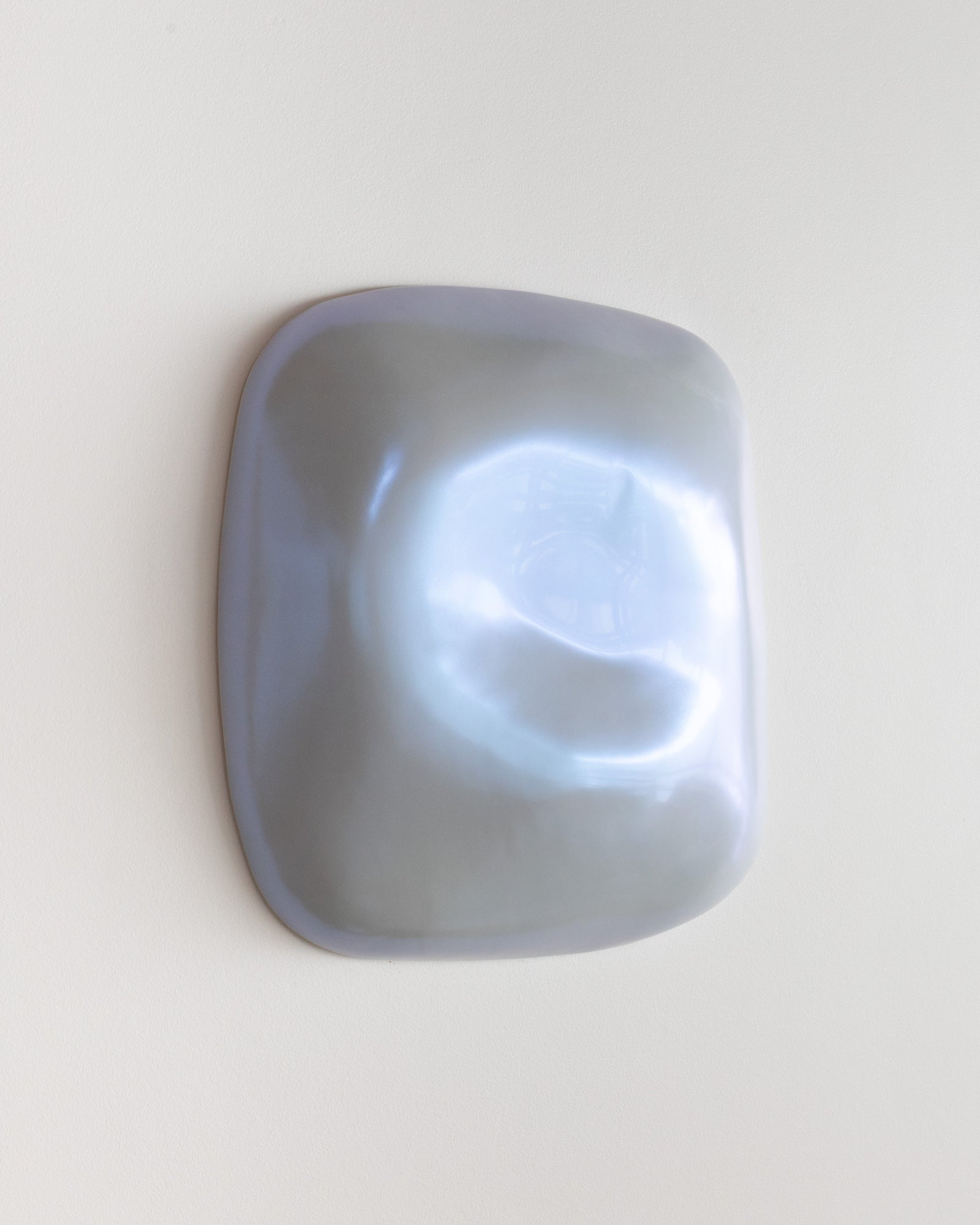Close-up of a pale blue ceramic fragment with glossy highlights
