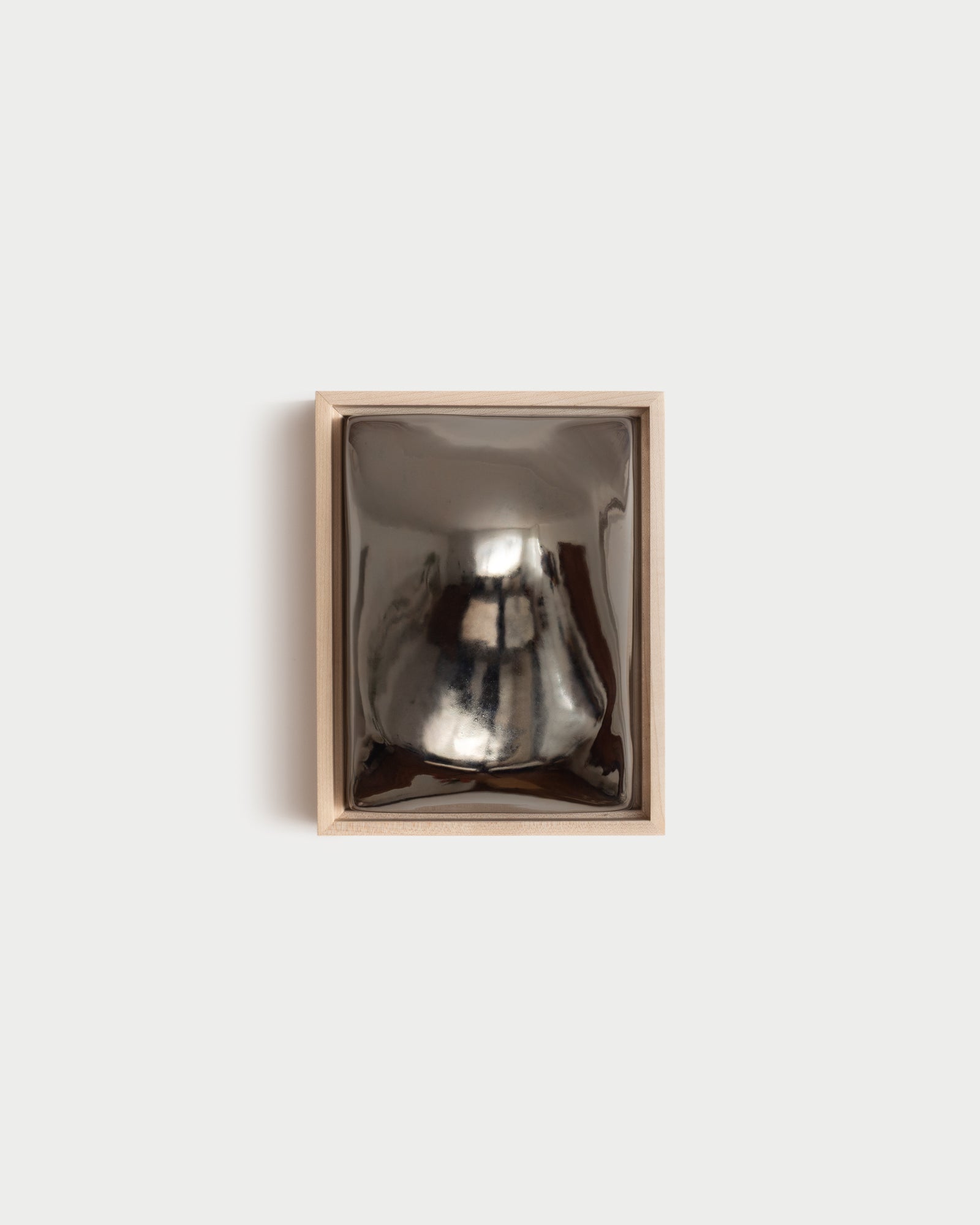Float 6x8" ceramic wall relief with a rounded raised form and dark chrome glaze