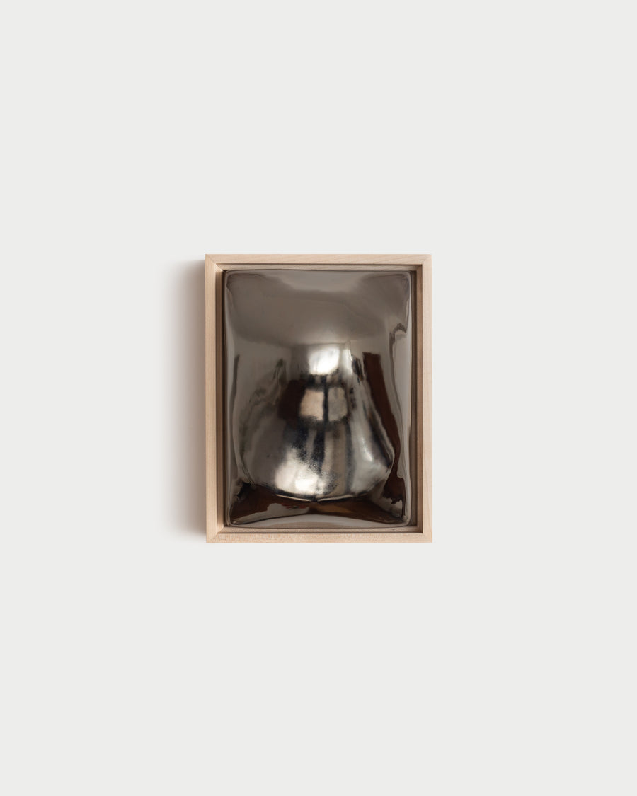 Float 6x8" ceramic wall relief with a rounded raised form and dark chrome glaze