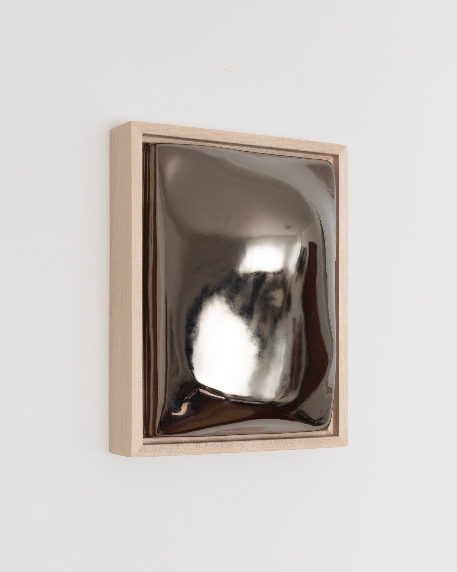 Close-up detail of Float showing the rounded raised form and dark chrome glaze