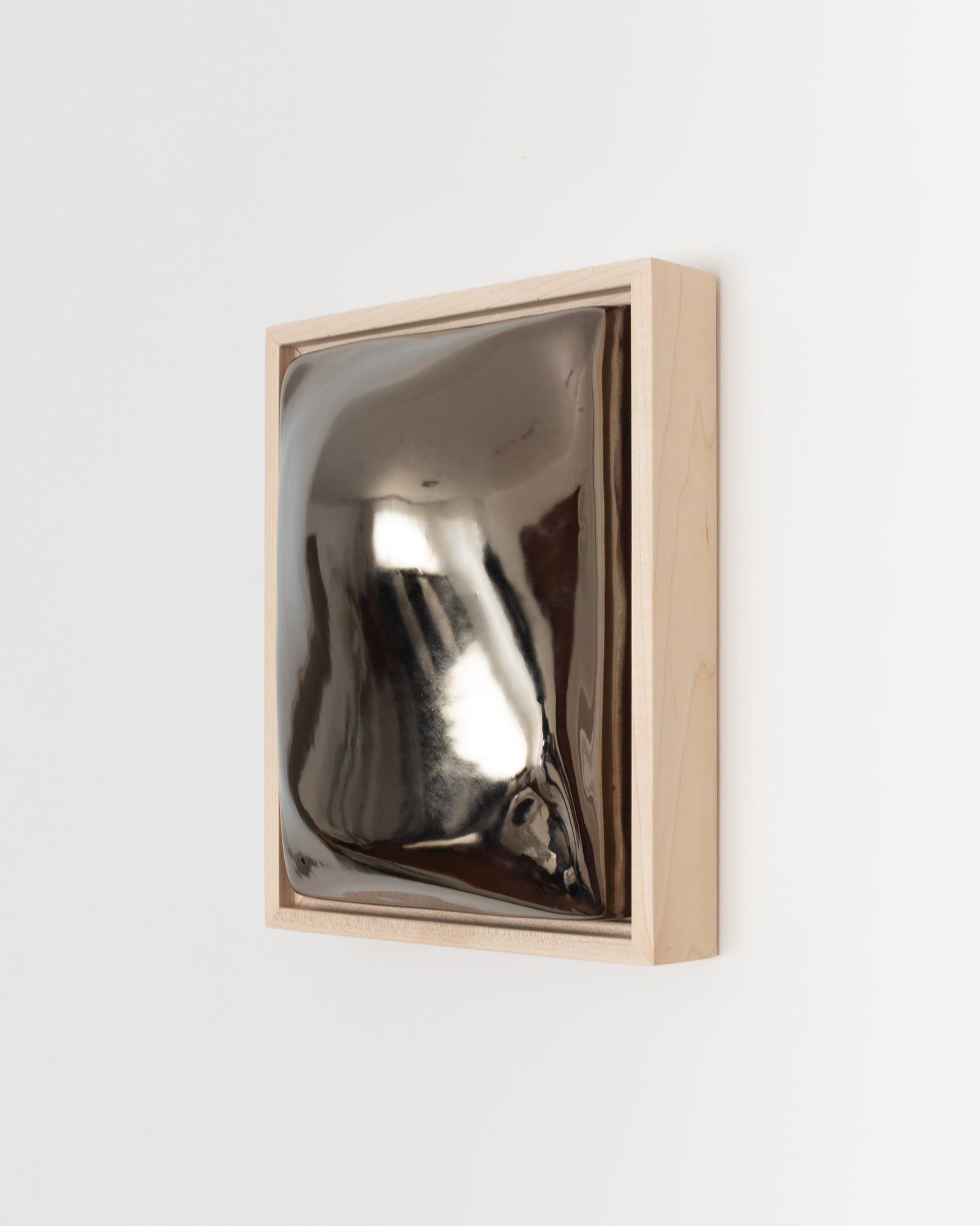 Side detail of Float showing the framed ceramic wall relief and dark chrome glaze