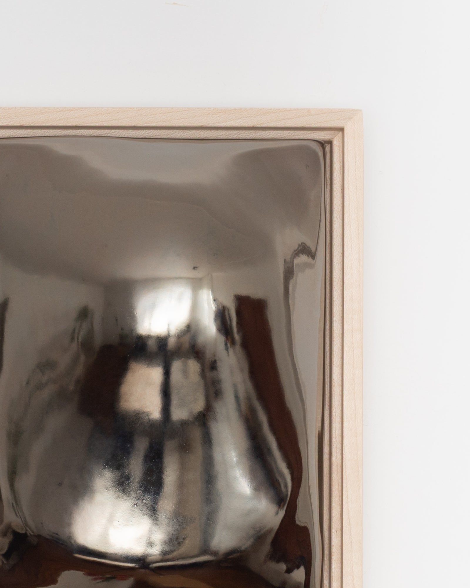 Angled detail of Float showing the rounded raised form and dark chrome glaze