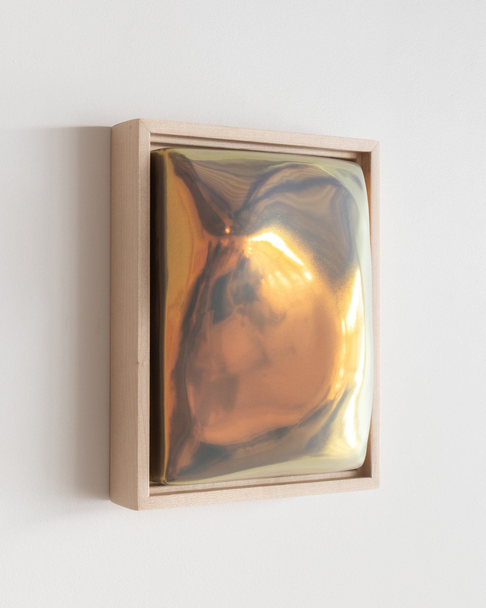 Angled detail of Hold showing the framed ceramic wall relief and iridescent glaze