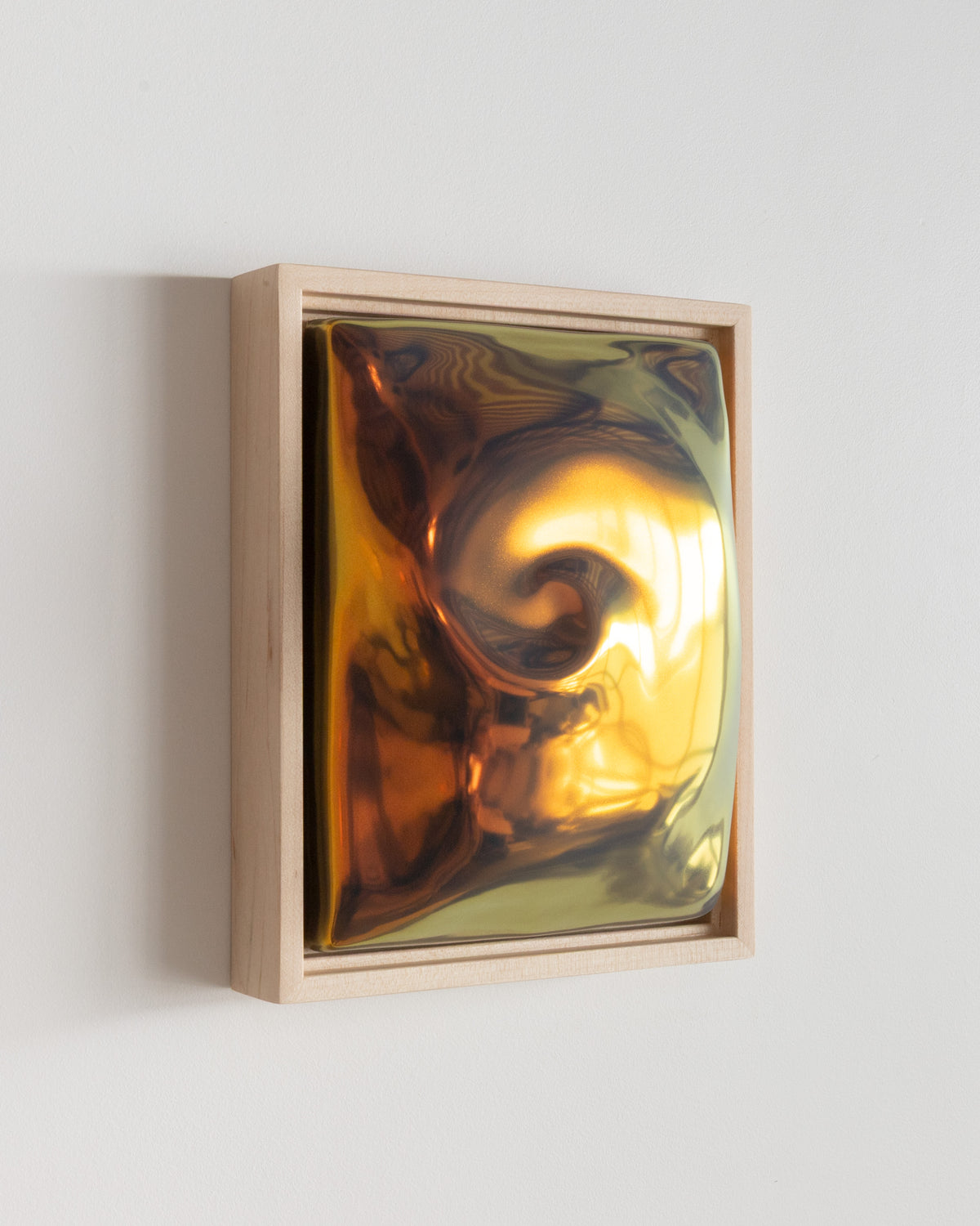 Angled detail of "Nautilus" showing the framed ceramic wall relief and iridescent glaze