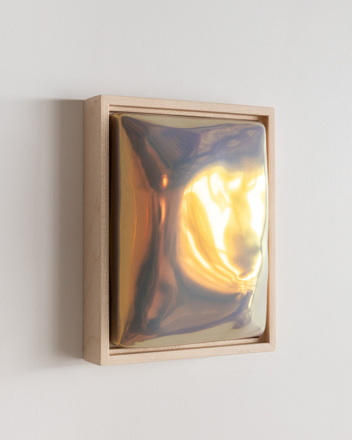Angled detail of "Sway" showing the framed ceramic wall relief and iridescent glaze