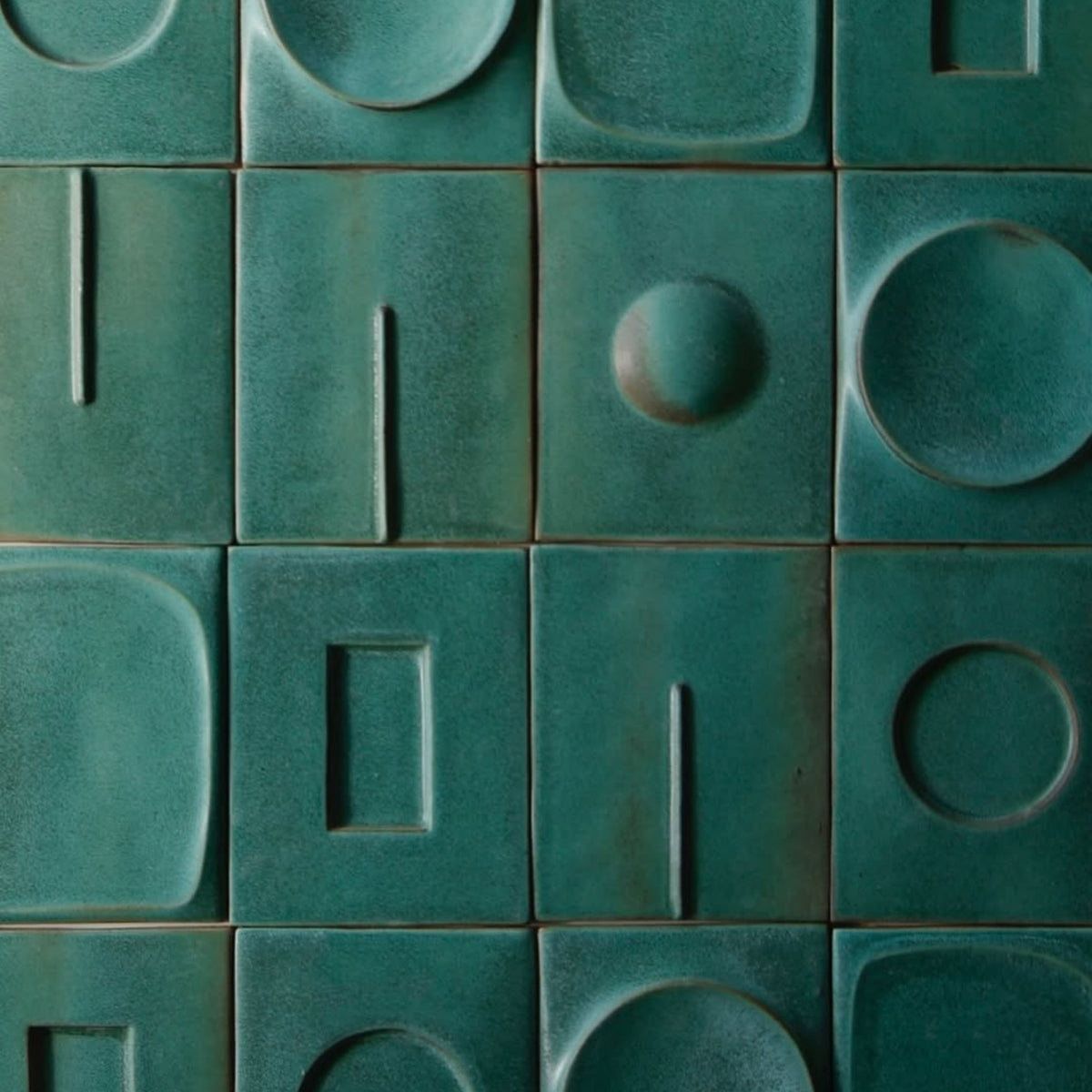 Green ceramic tile installation with raised geometric shapes