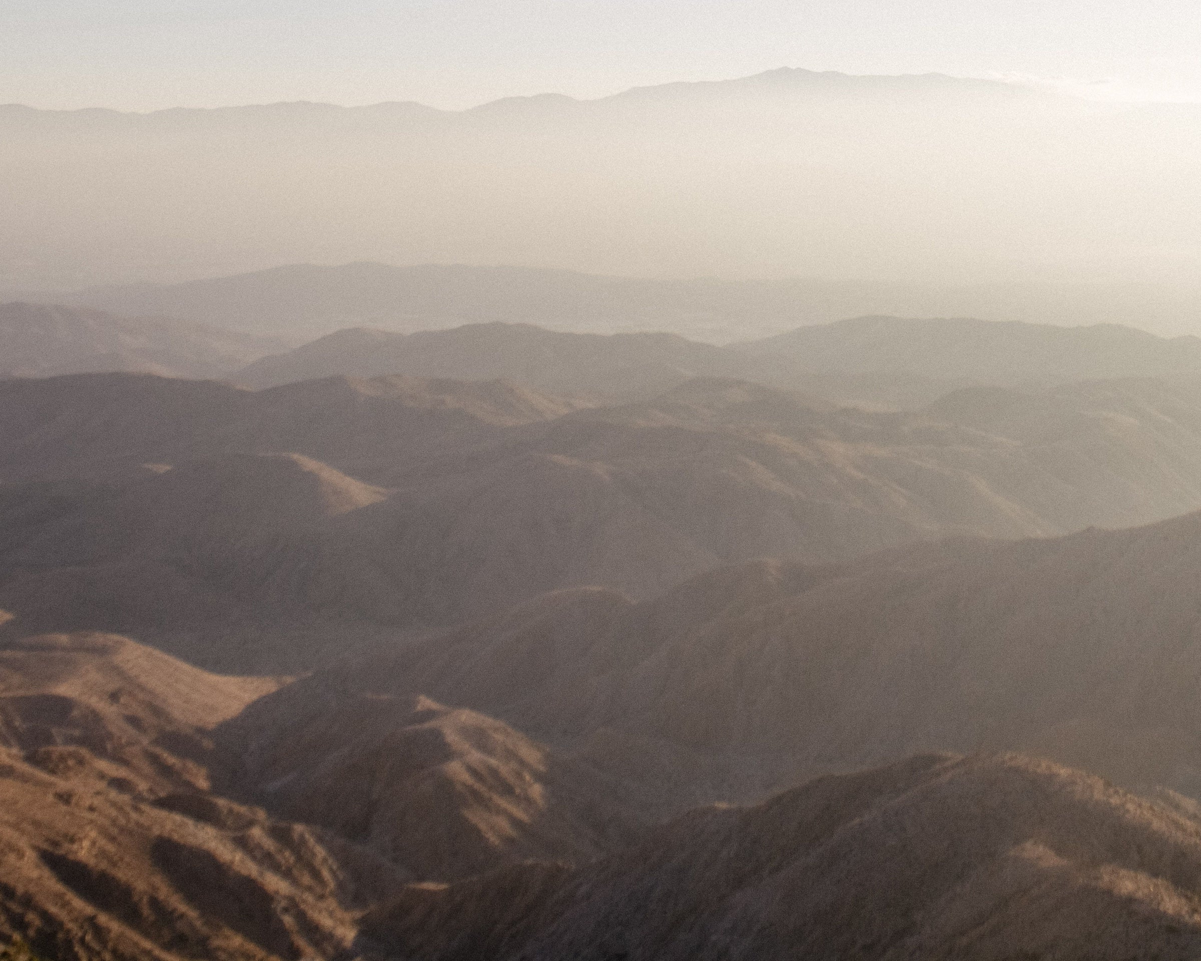 Layered mountain landscape in hazy neutral tones