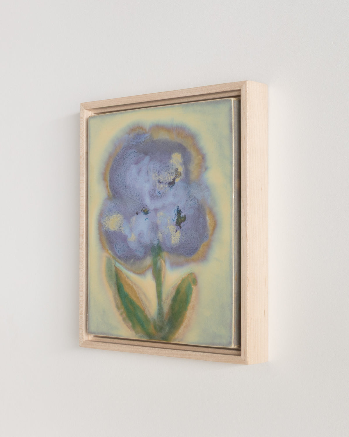 Detail of "Pollen" showing a large blue flower and green leaves in a wood frame