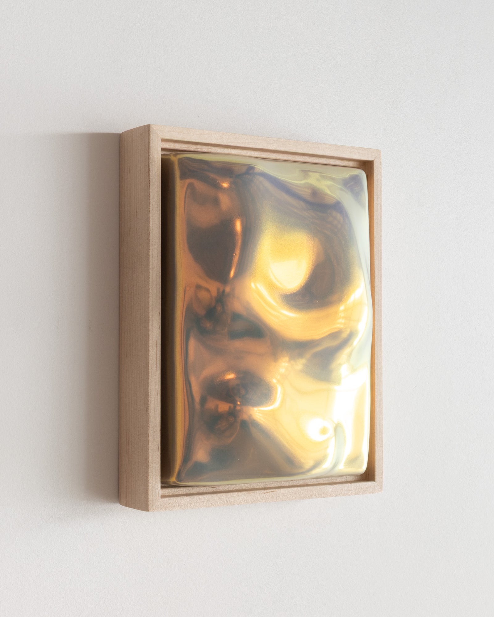 Angled detail of Flora showing the framed ceramic wall relief and iridescent glaze