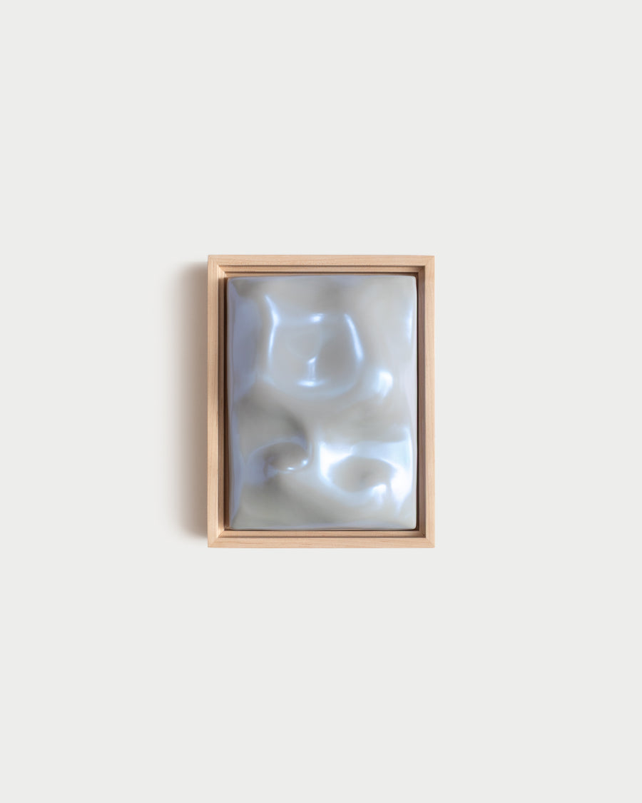 Small pale blue framed ceramic wall relief on a white wall
