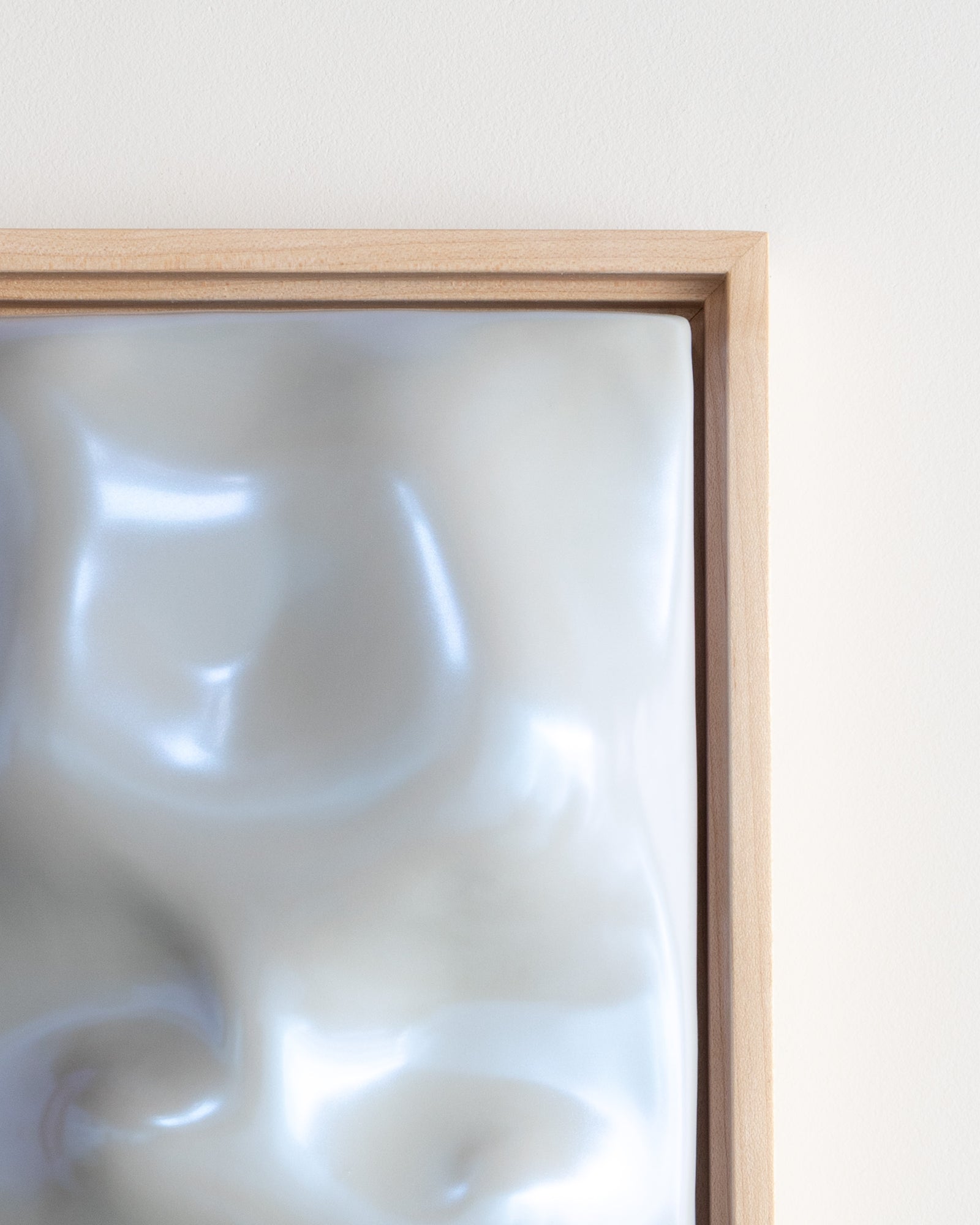 Close-up of a pale blue framed ceramic relief surface