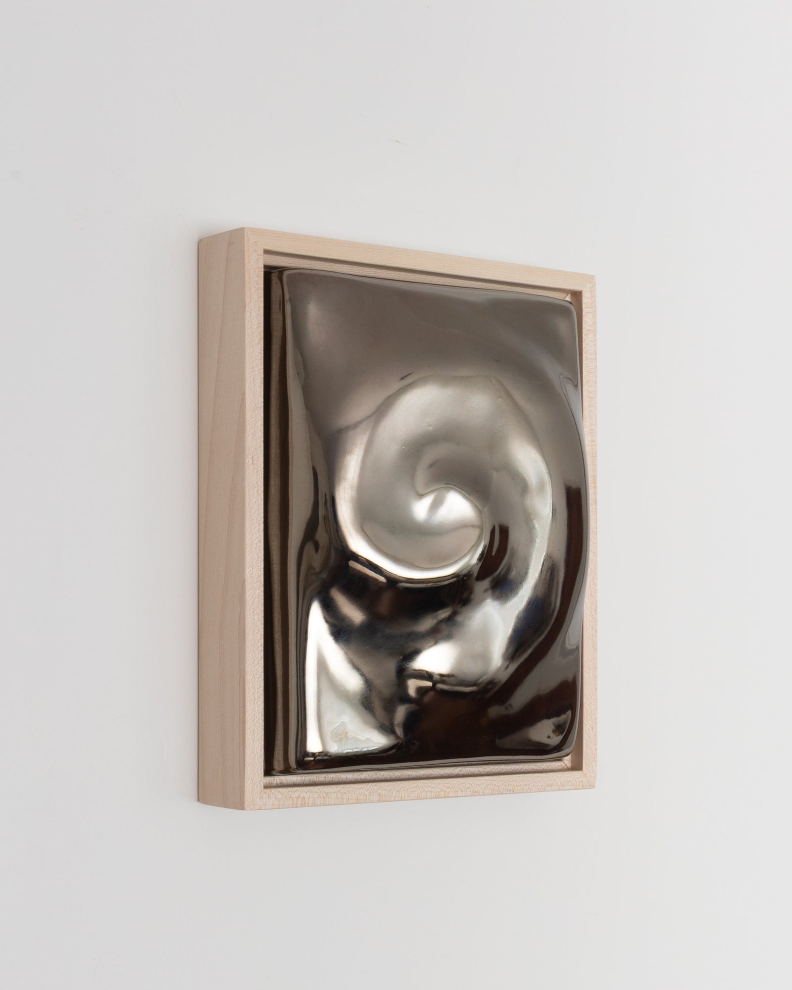 Close-up detail of Nautilus showing the raised spiral form and dark chrome glaze