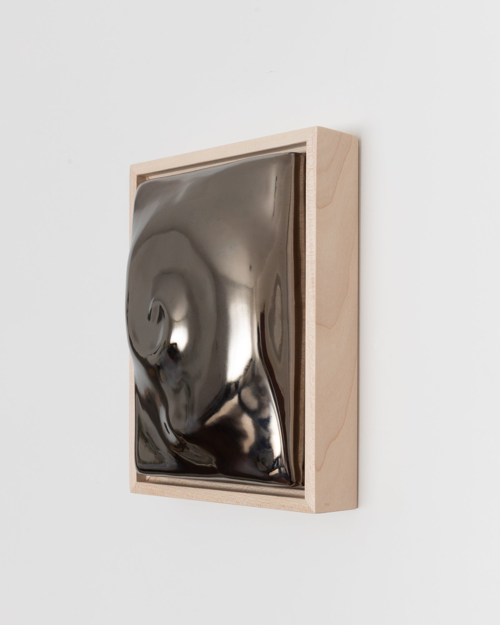 Side detail of Nautilus showing the framed ceramic wall relief and dark chrome glaze
