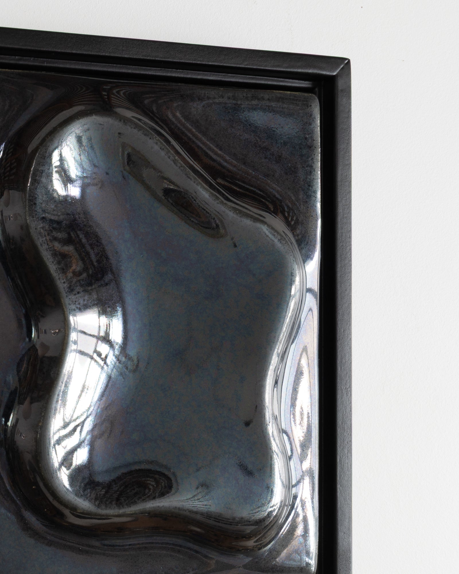 Close-up of a black reflective ceramic relief surface