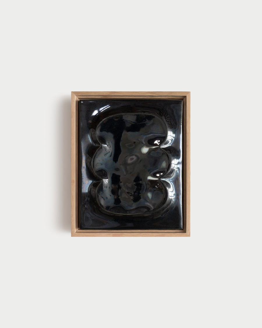 Small black framed ceramic wall relief with raised organic forms