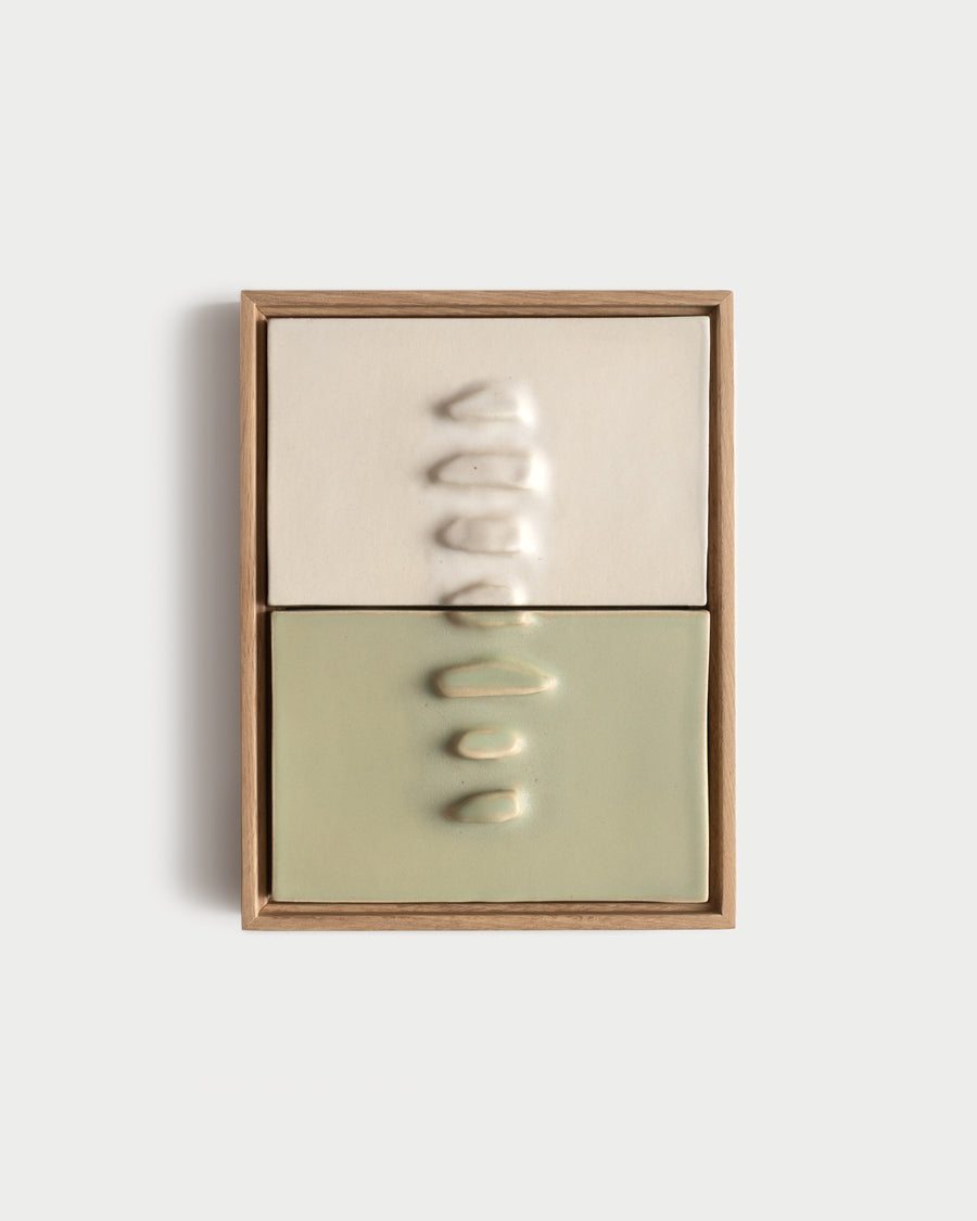 Framed two-panel ceramic wall relief in white and pale green