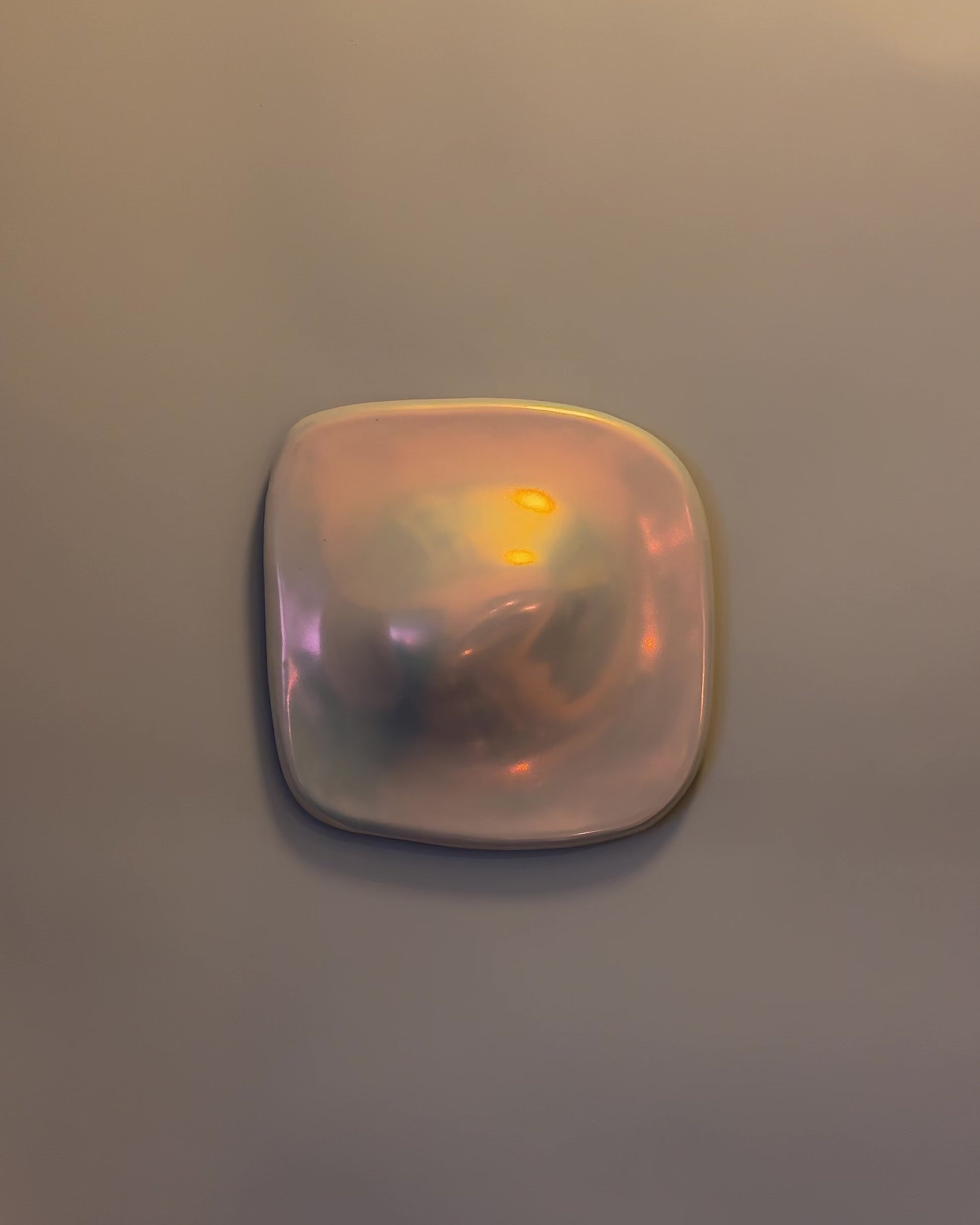 Video of a small iridescent ceramic wall relief in golden light