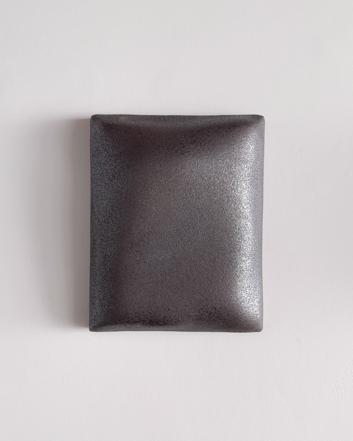 Video thumbnail of a dark stone ceramic wall relief with softly rounded edges