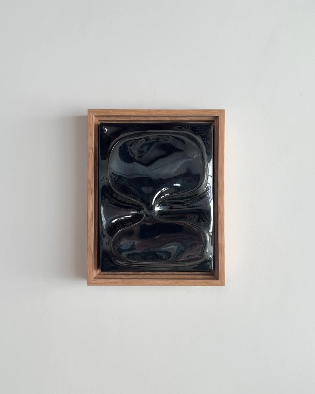 Video thumbnail of a small black reflective ceramic wall relief