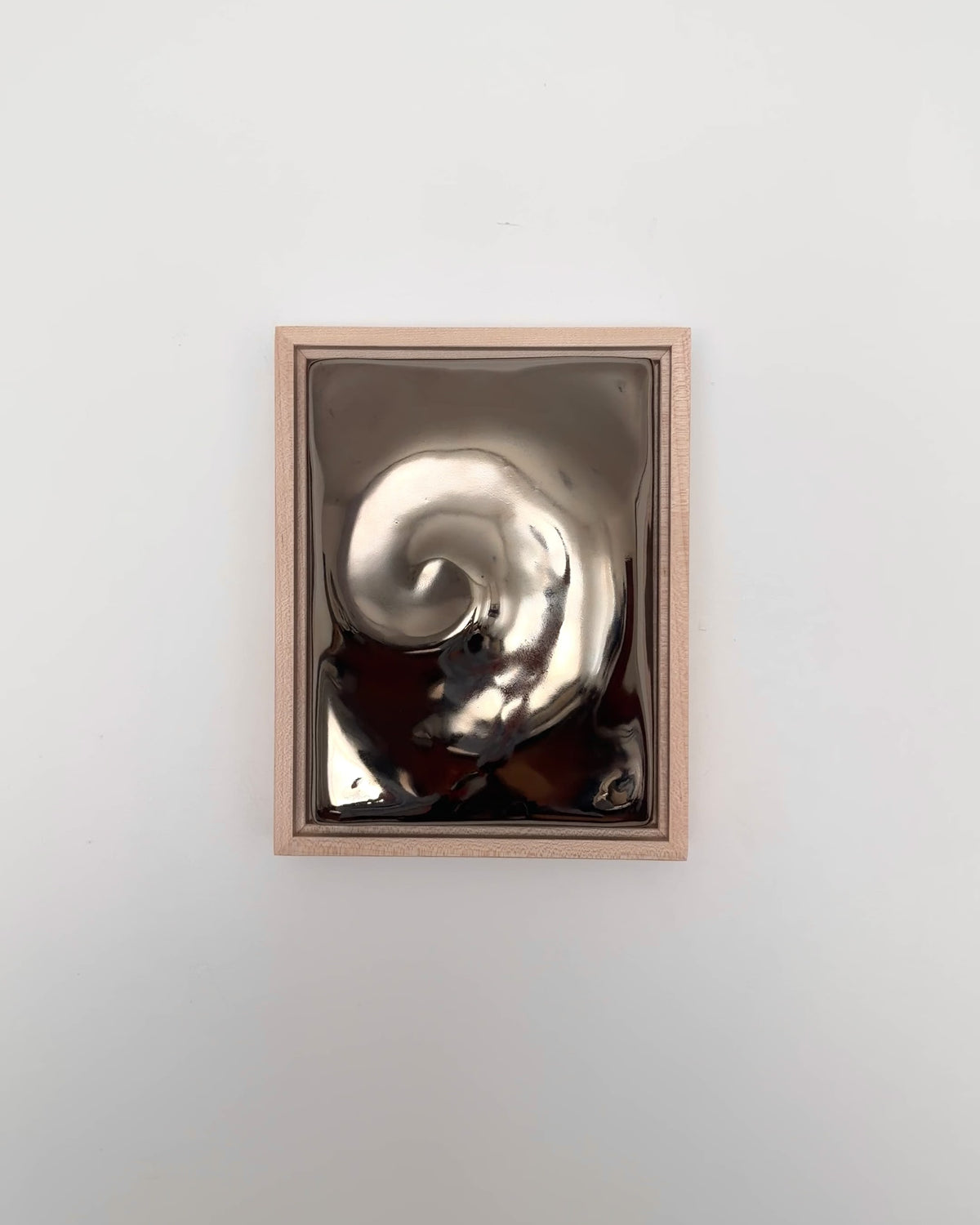 Video of Nautilus 6x8" ceramic wall relief showing the raised spiral form and dark chrome glaze