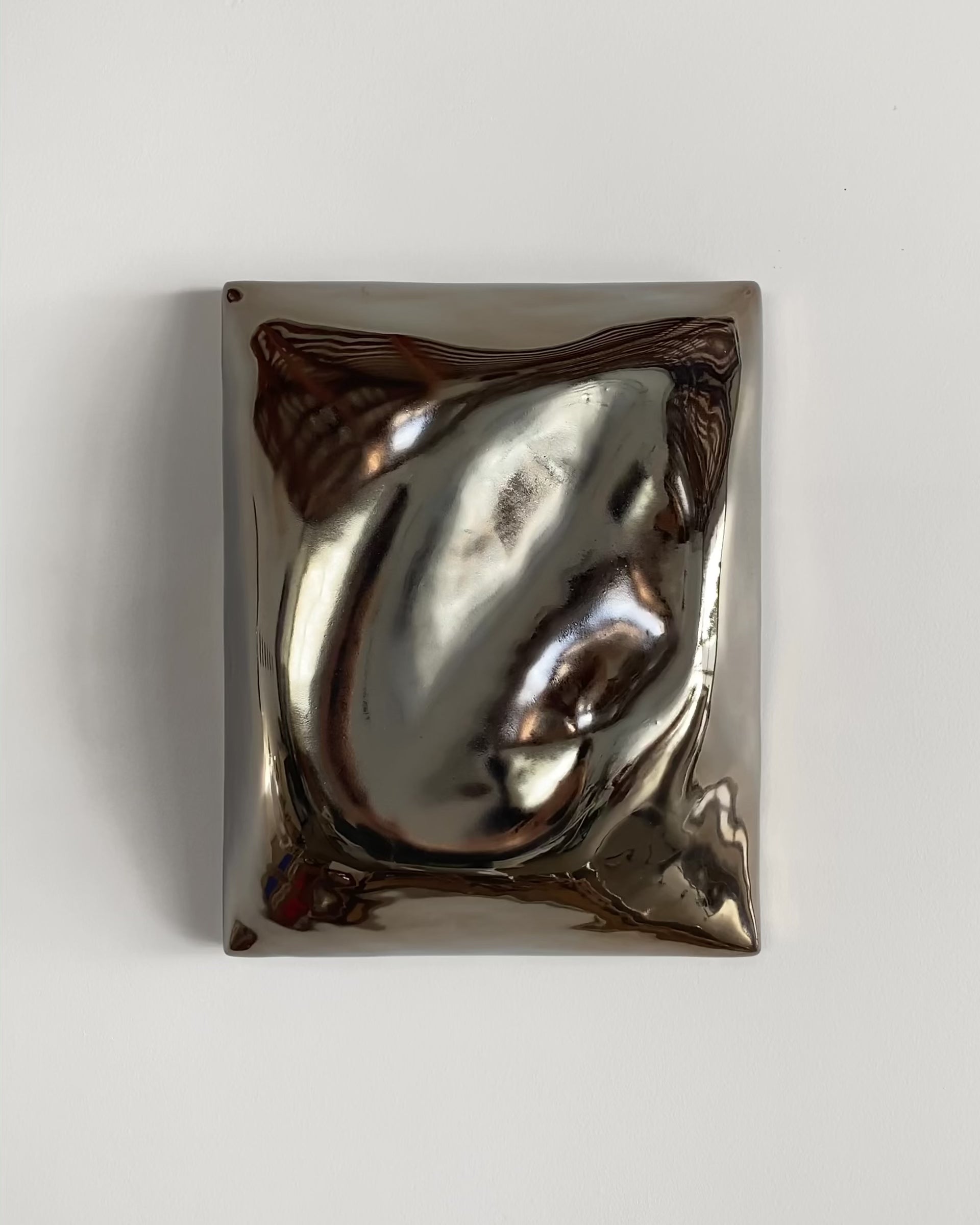 Video of a dark chrome ceramic wall relief with glossy raised forms